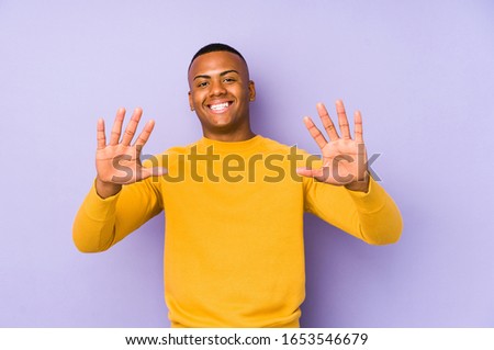 Young latin man isolated on purple background showing number ten with hands.