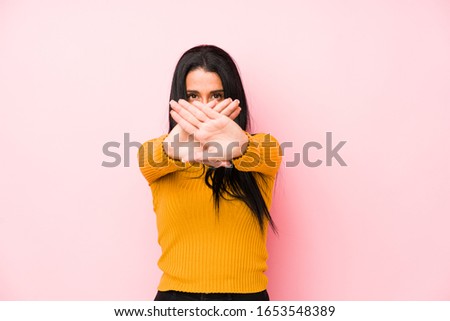 Young caucasian woman isolated on a pink background doing a denial gesture