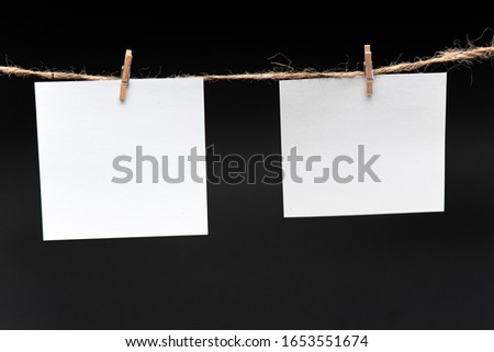 Blank Paper, hanging on rope by pin against black background, concept, office