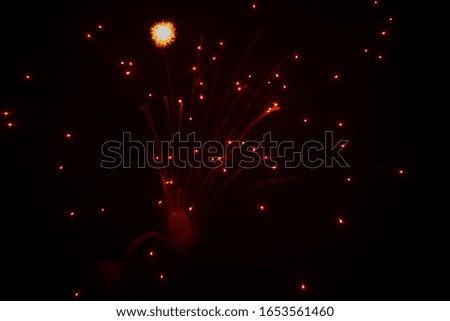 Red fireworks in the night sky.