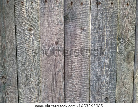 old wooden fence with vertical boards and peeling light paint