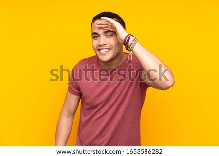 Asian handsome man isolated on yellow background making stop gesture with her hand to stop an act
