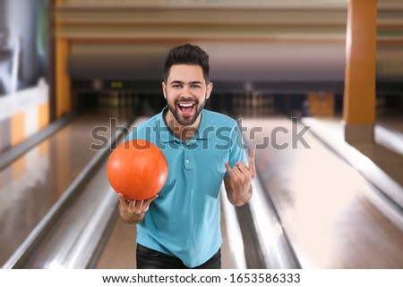 Young man with ball in bowling club