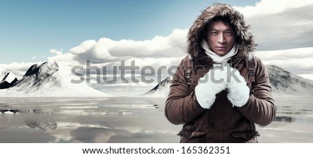 Asian winter sport fashion man with backpack in snow mountain landscape. Wearing brown jacket with fur hoody and white gloves. Royalty-Free Stock Photo #165362351