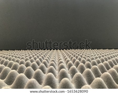 Selective focus images of Polyurethane foam soundproof panel pattern with the black grey background. Sound insulation material.