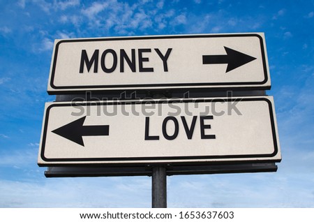 Money vs love. White two street signs with arrow on metal pole with word. Directional road. Crossroads Road Sign, Two Arrow. Blue sky background. Two way road sign with text.
