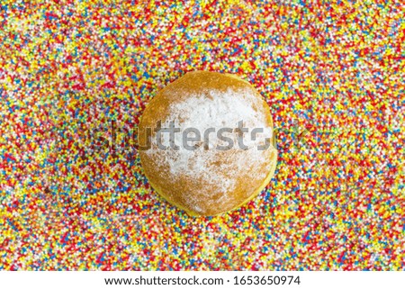 Donut in a sea of colorful sprinkles