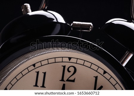 Black retro alarm clock showing differnt times