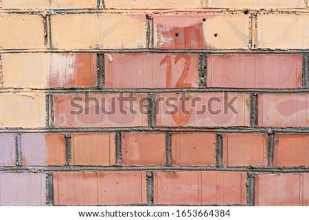 Red Brick Wall painted with yellow stain, Abstract Background Texture. Stock Photo