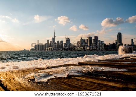 The Toronto skyline behind as viewed from Polson Pier as the sun is setting on a cold winter day.