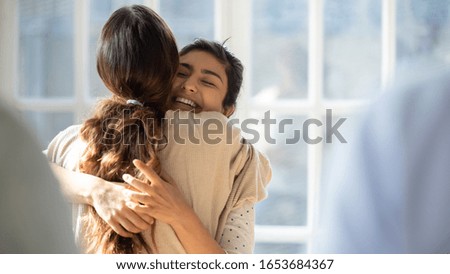 Rear view female cuddle Indian best friend glad to see each other enjoy tender moment show friendly relation and affection, woman psychologist counsellor hug girl supports her at group therapy session Royalty-Free Stock Photo #1653684367