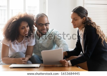 Couple at meeting with realtor discussing contract terms, customers considering variation quotation with broker, agreement between contractor and client tenants insurance formal document offer concept Royalty-Free Stock Photo #1653684445