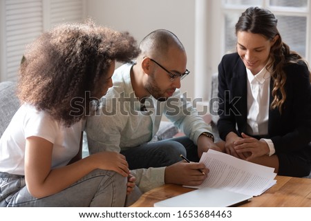 African couple meet with notary or lawyer discuss prenuptial agreement, before sign rental tenancy contract legal document pages spouses read conditions, banker and clients loan lease mortgage concept Royalty-Free Stock Photo #1653684463