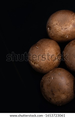 Stock photo of overhead view of group of mushrooms on black background.