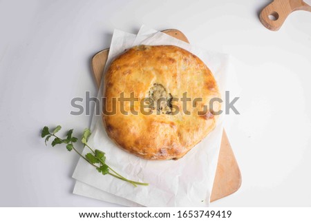 khachapuri pie with meat served on a board on a white background