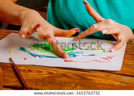 Art therapie and creativity concept. Beautiful young woman painting with finger