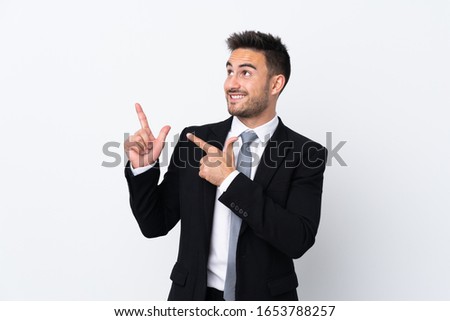 Young business man over isolated background pointing with the index finger a great idea
