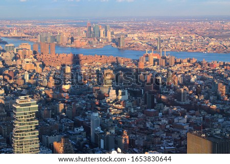 Breathtaking cityscape of the New York City from bird's eye view, panorama colored in gold and blue by sunset, twilight evening time. Old buildings and skyscrapers in amazing view on Manhattan Island.