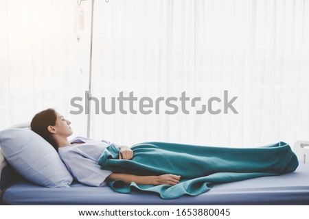 Patient person sleep on patient bed in hospital room. Sick woman get high fever. Illness girl get Surveillance or quarantine symptoms in separate patient room. She get tired, weak. Patient get cancer Royalty-Free Stock Photo #1653880045