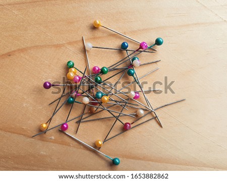 Plastic head pin with a colored head against a wooden background