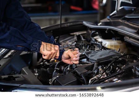mechanic hand using wrench to repair the engine, car service Royalty-Free Stock Photo #1653892648