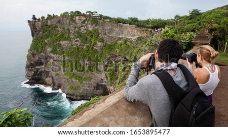 Travel photographer with digital camera making photo.