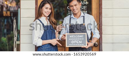 Banner of Asian partner Small business owner hands holding and showing the chalkboard with Welcome Open sign in front of coffee shop, startup with cafe store, installing open and close label concept