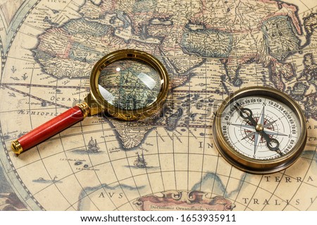 Retro compass with old map and magnifier Royalty-Free Stock Photo #1653935911