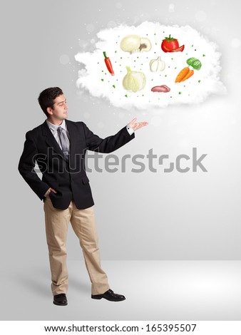 Handsome man presenting a cloud of healthy nutritional vegetables concept
