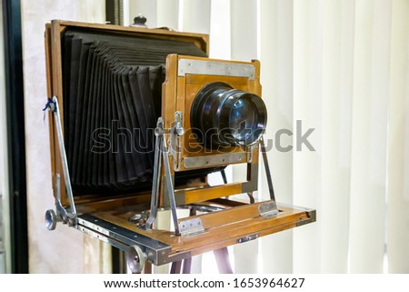 Very old rustic vintage large format camera as decoration in a room again white background. Side view.