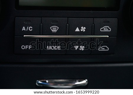 Turning on the air conditioning of a car on the climate control panel. Royalty-Free Stock Photo #1653999220