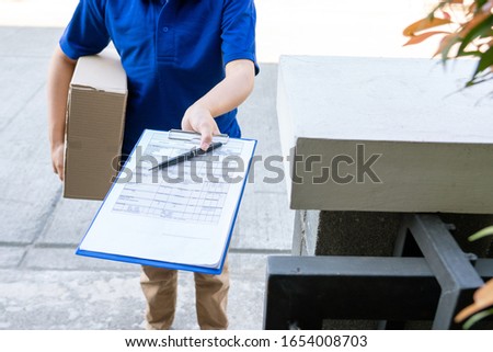 courier delivery man checking or holding cardboard parcel package to deliver to client for accepting a delivery of boxes