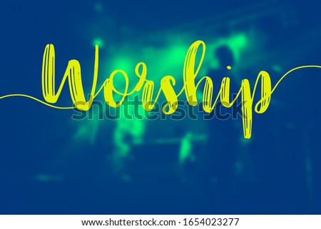 The word of "Worship" and the hall in church christian music concert.Blurred background of people raised hands and shouting worship concert.Christian background for worship.Duo tone.