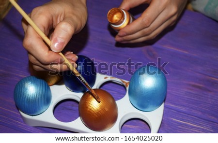 Girl decorates the easter eggs