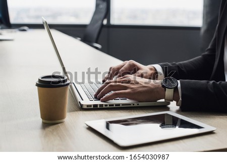 Businessman working on computer. Young man hands using laptop in office. Internet marketing, finance, technology business concept
