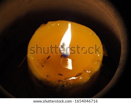 The picture of a candle lit in the dark