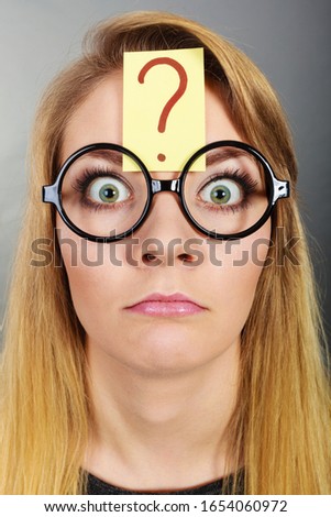 Crazy wondering face expression concept. Wierdo nerd woman having question mark on forehead and geek eyeglasses.