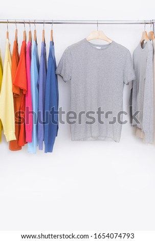  fashion and ad concept. Hanger with row of t-shirts with sweatshirt on hanging


