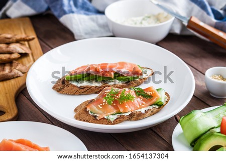 healthy sandwiches toats with salmon avocado cucumber  cream cheese dill on plate