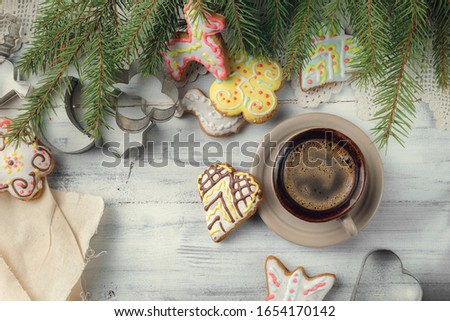 Cup of black coffee with christmas tree and gingerbread cookies, top view