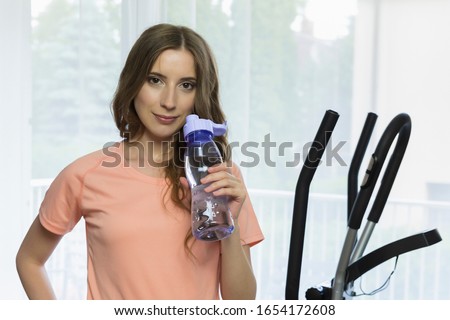 Young slim girl goes in for sports at home. A conceptual photo about the benefits of sports and a healthy lifestyle.