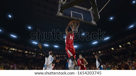 Basketball players on big professional arena during the game. Tense moment of the game. View from below the basket