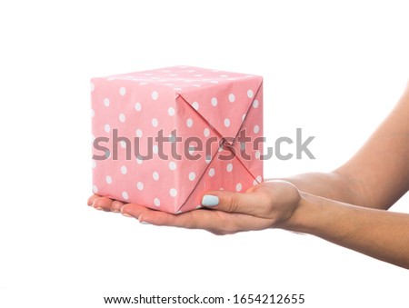 female hand holds a beautiful gift box with a bow isolated on white background