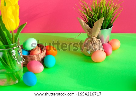 Vibrant colored eggs in a nest on green. Easter concept