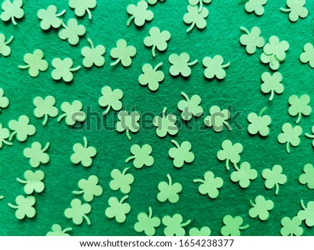 St. Patrick's Day background concept. Green clovers from paper on a green background. Copy space. Top view. 