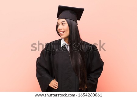 young latin woman student looking happy, cheerful and confident, smiling proudly and looking to side with both hands on hips