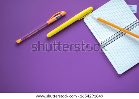 School supplies on purple background. Notebook open page. Workspace of student or office worker