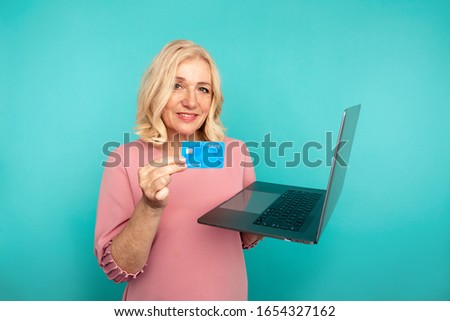 Woman using internet for online shopping with computer and credit card.