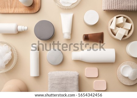 Flat lay composition of beauty cosmetic skincare products in various tubes and bottles on beige background