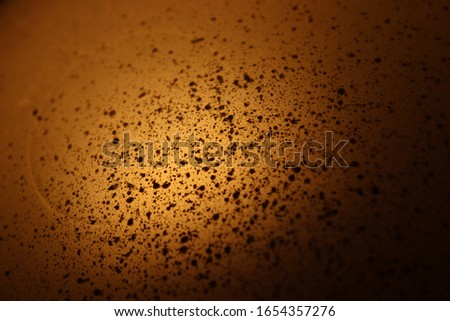 Golden brown background with little dirty black dots